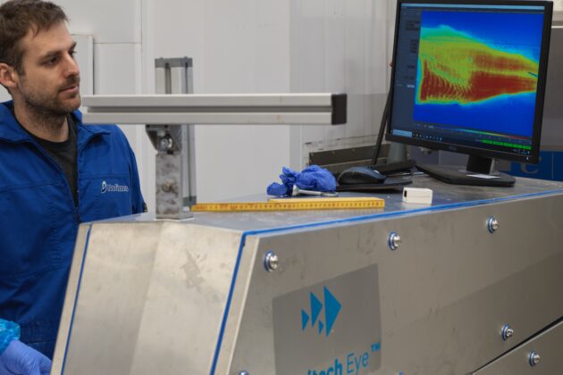 Forsker står ved maskinen som viser avbildingen av torsk på sin skjerm.